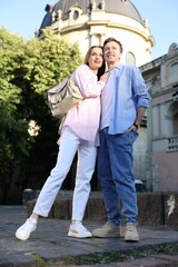 Lovely couple walking together on city street, low angle view