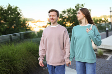 Lovely couple walking together on city street, space for text