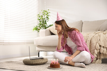 Birthday celebration. Happy woman with tasty cake having video call via laptop at home