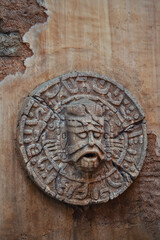 A detailed stone carving depicting a mans face on a wall surface