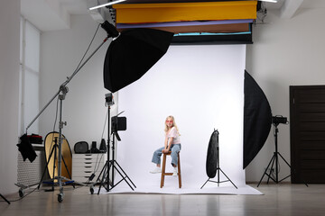 Little girl on white background in photo studio with professional equipment