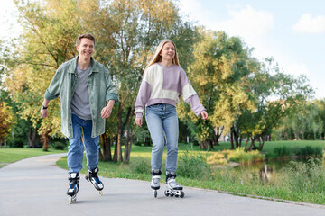 Happy couple roller skating together in park