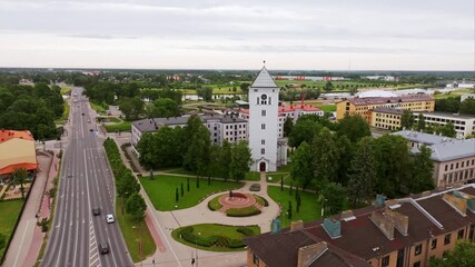 Jelgava&#x27;s white tower and national monument appear beneath cloudy summer sky