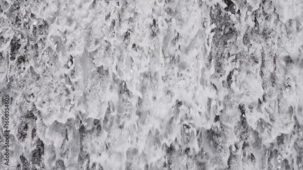 Poster close-up of water splashing down a waterfall, creating white foam and dynamic natural flow.