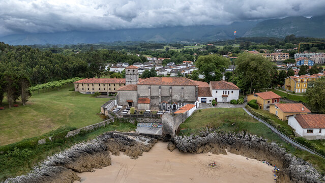 Luftaufnahme von Dorf, Kirche und K&uuml;stenlandschaft in Celorio (Asturien)