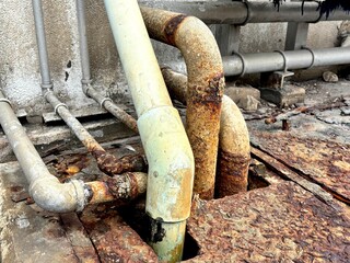 Rusty and corroded metal pipes in an industrial area, showing neglect and the urgent need for pipe...