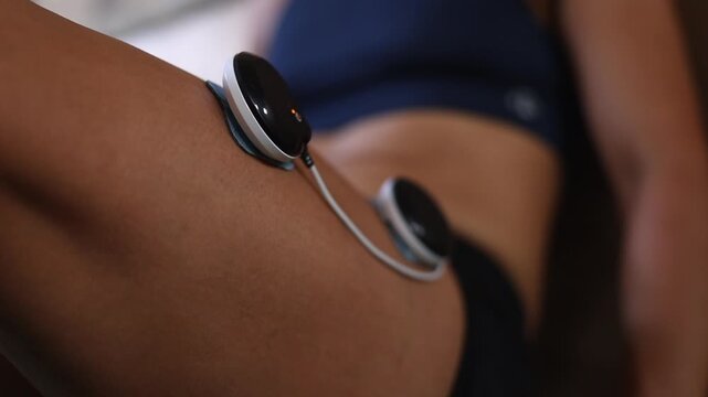 Closeup narrow focus: Muscle stimulation electrodes flex quad muscles
