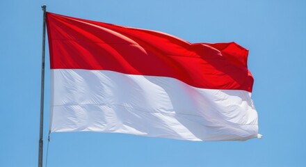 The national flag of Indonesia, Sang Saka Merah Putih, waving powerfully in the wind on a tall flagpole.