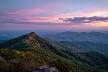 Obraz premium Lush mountains at sunset under a pink and purple sky create a serene vista