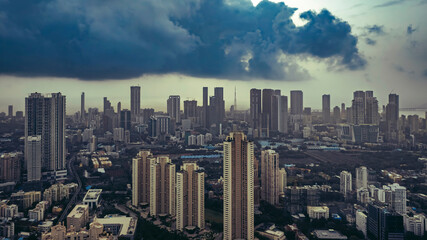 Aerial cinematic image of Mumbai during the monsoon season, featuring dramatic clouds over the city skyline. Ideal for themes like weather, travel, cityscapes, and dramatic skies.