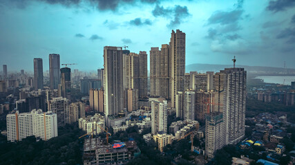 Aerial cinematic image of Mumbai during the monsoon season, featuring dramatic clouds over the city skyline. Aerial view of the Bandra-Worli Sea Link in Mumbai, India.