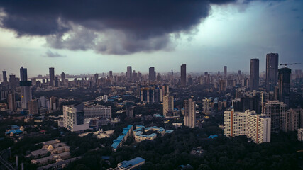 Aerial cinematic image of Mumbai during the monsoon season, featuring dramatic clouds over the city skyline. Aerial view of the Bandra-Worli Sea Link in Mumbai, India.