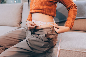 woman's hand holding excessive belly fat, overweight concept