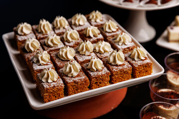 Carrot cake slices with cream topping and powdered sugar