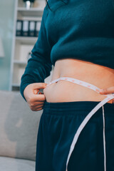 woman's hand holding excessive belly fat, overweight concept