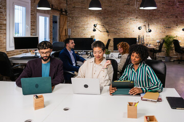 Multi ethnic team collaborating on project in modern office