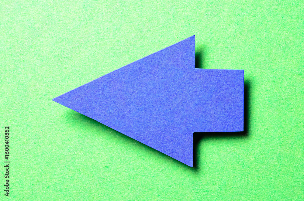 Poster blue cut out blank paper cardboard arrow direction sign with copy space for text on green background