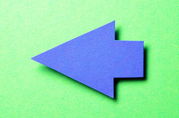 Blue cut out blank paper cardboard arrow direction sign with copy space for text on green...
