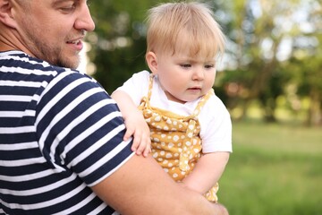 Smiling dad and his newborn baby outdoors, closeup. Happy Father's Day