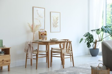 Beautiful table setting, chairs and decor in dining room. Interior design