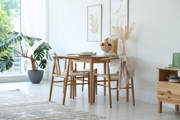 Beautiful table setting, chairs and decor in dining room. Interior design