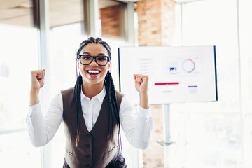Confident businesswoman celebrating success in modern office setting during corporate presentation...