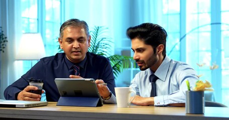 Indian businessmen working on tablet computer in modern office at desk, Asian young corporate executives discussing teamwork collaboration strategy, planning goals and digital project in office - Powered by Adobe