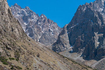 Ala-Archa Park, Towering jagged mountains, featuring rocky ridges, high altitude terrain, patches...