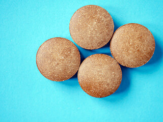 Brown herbal pill tablet on blue background