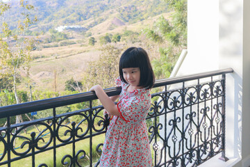 Cute little asian girl at the resort with mountain view