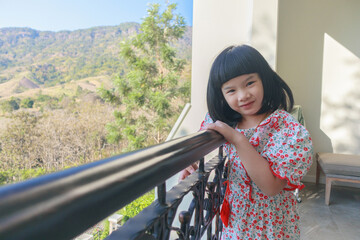 Cute little asian girl at the resort with mountain view