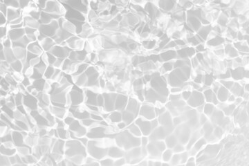 White water with ripples on the surface. Defocus blurred transparent white colored clear calm water surface texture with splashes and bubbles. Water waves with shining pattern texture background.