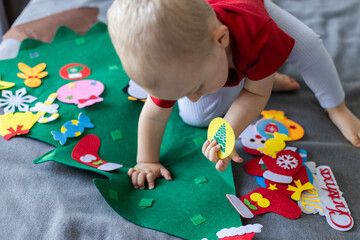 Little child with toy Christmas tree. Educational games for children.