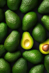 Fresh avocados arranged artfully on a dark surface, showcasing ripe and sliced fruits