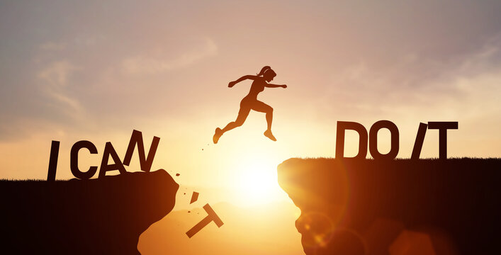 Silhouette of woman jump across cliff with word I CAN DO IT. Concept of self-confidence and the drive to overcome any obstacles towards future success.