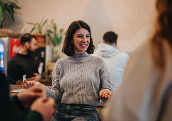A cheerful woman enjoys quality time with friends in a cozy social setting, radiating joy.