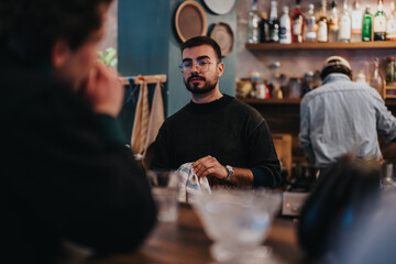 Two friends and a friendly bartender are having a lively conversation in a relaxed lounge bar setting.