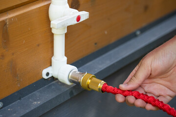 The tap with the adapter for connecting to the hose for use in the garden, garden hose reel on wall...
