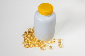 Medicine Bottle with Yellow Cap and Scattered Capsules