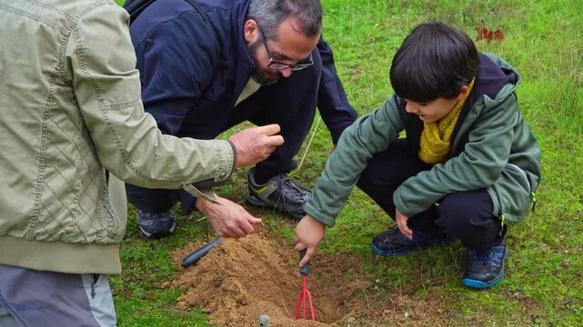 Grandfather, father and child planting flowers together on a spring garden
