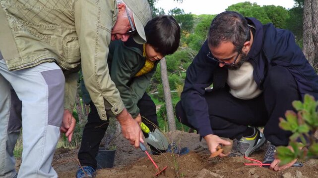Multiethnic family planting trees together in urban forest