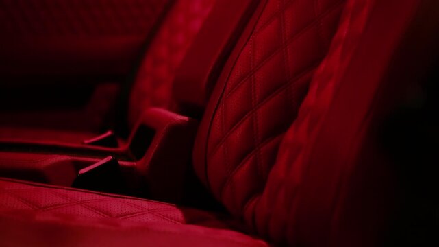 Close-up view of luxurious red leather car seats featuring diamond stitching pattern, highlighting premium craftsmanship and modern automotive interior design aesthetics