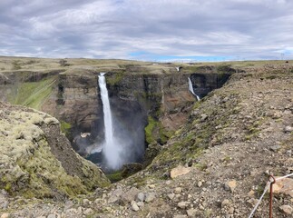 panoramic view of the deep canyon in the Icelandic fossardalur valley with the Haifoss and Grannifoss waterfalls plummeting into the deep