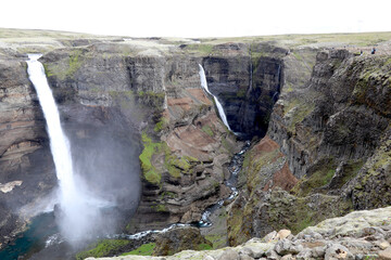 panoramic view of the deep canyon in the Icelandic fossardalur valley with the Haifoss and Grannifoss waterfalls plummeting into the deep
