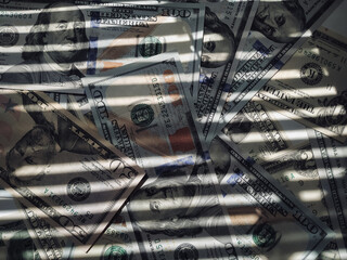 The horizontal shadow of the blinds resembles the grid on dollar bills. The concept of prison,...