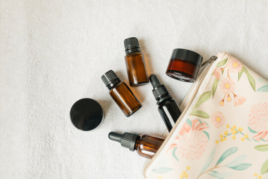 Collection of amber essential oil products spilling from small purse