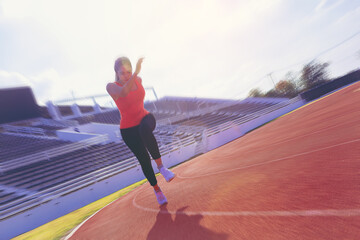 Fit young woman running sprinting at the racetrack. Fit runner fitness runner during outdoor workout at racetrack.