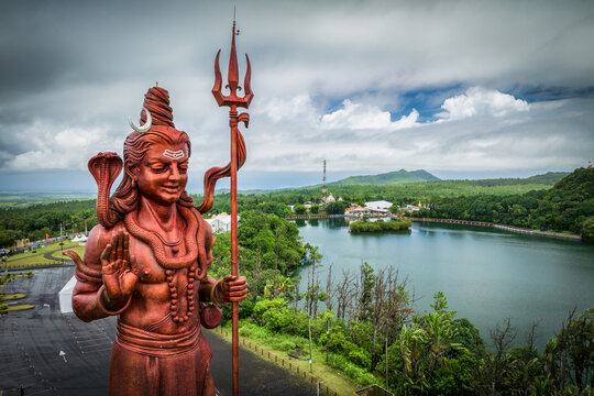 Aerial view of the majestic statue of Lord Shiva standing tall against the backdrop of the serene Ganga Talao lake and lush greenery, Grand Bassin, Mauritius.