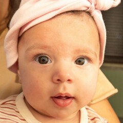Young mother cradles five month baby girl in vintage wood paneled hallway

