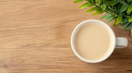 Overhead View of Coffee Cup on Wooden Table with Green Plant